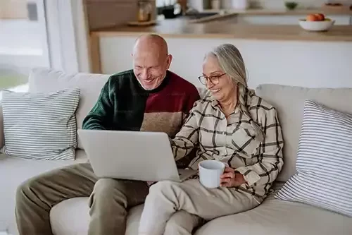 Couple sitting on a sofa booking a site visit with Roots Landscapes and Trees